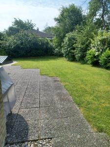 Un jardín con un patio de césped y un banco. en Küstenbude große Auszeit, en Grömitz