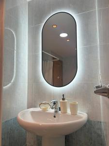 a bathroom with a sink and a mirror at Living Home - Centro Ciudad in Murcia