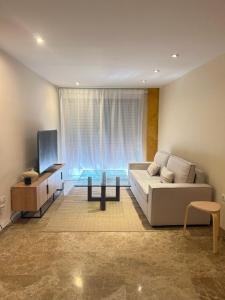a living room with a couch and a table and a tv at Living Home - Centro Ciudad in Murcia
