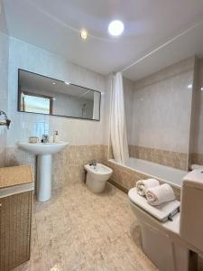 a bathroom with a sink and a toilet and a tub at Living Home - Centro Ciudad in Murcia