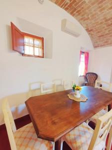 RinecchiにあるCasa Isabella- Barbecue, Giardinoの木製のテーブルと椅子のあるダイニングルーム