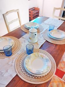 RinecchiにあるCasa Isabella- Barbecue, Giardinoの皿とグラスが置かれた木製のテーブル