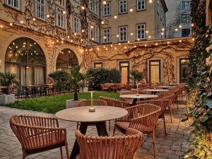una fila di tavoli e sedie di fronte a un edificio di Radisson Blu Das Triest Hotel, Vienna a Vienna