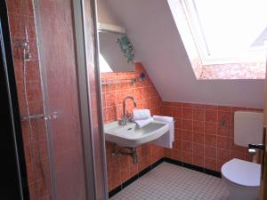 a bathroom with a sink and a toilet at Küstenlounge Dornumersiel in Dornum +7 photos