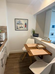 a small kitchen with a wooden table and white chairs at Haus Westerhörn in Westerland