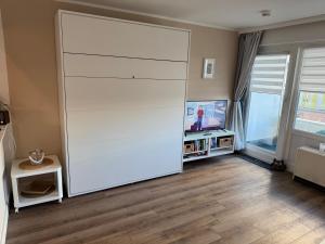 a large white closet in a room with a tv at Haus Westerhörn in Westerland +6 photos