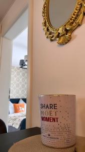 eine Tasse auf einem Tisch vor einem Spiegel in der Unterkunft Deluxe Apartement mit Terrasse in Duisburg