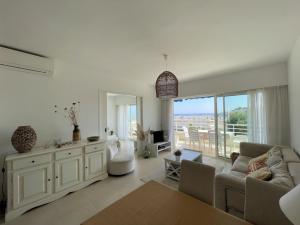 キャヴァレール・シュル・メールにあるGRAND PAVOIS Magnifique appartement climatisé, vue mer, piscineのソファとテーブルのあるリビングルーム +9枚の写真