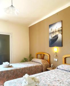 una camera con due letti e una foto di una barca di Hostal Lleida a Segur de Calafell