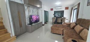 a living room with a couch and a flat screen tv at Nanzarie House in Bang Kew Yai