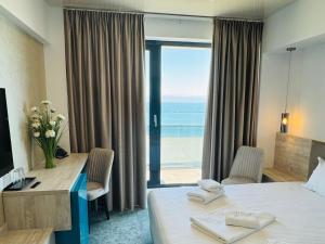 a hotel room with a bed and a view of the ocean at Hotel Alexandra in Mamaia