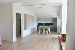 a living room with a green table and a kitchen at petiros in Arta Terme