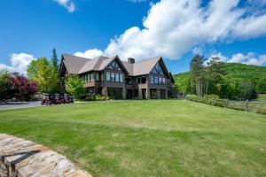 a large house with a large grass yard at Adventures at Big Canoe - Spacious Cabin Rental in Big Canoe - Serene Nature Views, Cozy Fireplace, Spacious Decks, Walking Dist in Afton