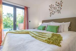 a bedroom with a large bed with green pillows at Villa Shanti, a luxurious and modern Villa surrounded by nature in Santalezi +23 photos