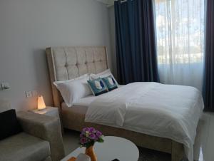 a bedroom with a bed with a chair and a couch at Cozy homes sabaki in Nairobi +13 photos