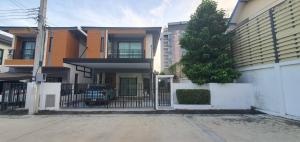 a house with a gate and a tree in front of it at Nanzarie House in Bang Kew Yai