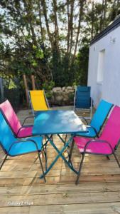 Un grupo de sillas y una mesa en un patio. en Studio neuf avec terrasse, en Saint-Pierre-Quiberon