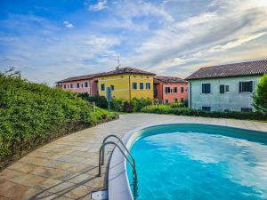 a swimming pool in front of a group of buildings at 10 minuti da Gardaland con Piscina e Giardino in Salionze