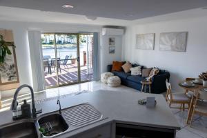 a kitchen and living room with a blue couch at Cosy Waterside Retreat in Port Lincoln