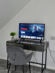 ロンドンにあるLIVNEST Apartment Wembley Parkのデスク、椅子、コンピュータモニタ