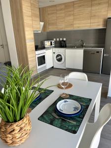 ナザレにあるMy beach's Apartments Poenteのキッチン(テーブル、グラスワイン付)