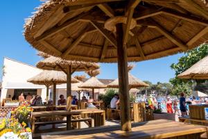 grupa stołów z parasolami na plaży w obiekcie Mobil-home au camping 5 étoiles L'Oasis Village - Montana Parc w mieście Puget-sur Argens