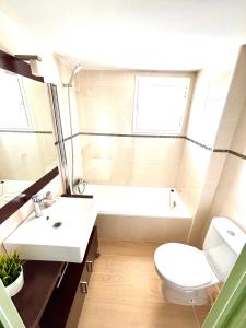 a bathroom with a white toilet and a sink at Apartamento reformado con piscina en Javea in Jávea