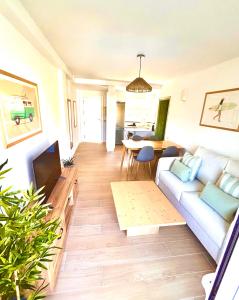 a living room with a couch and a tv at Apartamento reformado con piscina en Javea in Jávea +10 photos