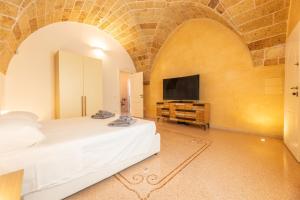 a bedroom with a bed and a flat screen tv at Villa La Gioconda in Neviano