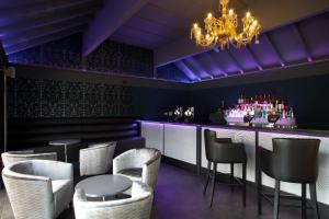 a nightclub with purple lighting and a bar with stools at Marwell Hotel Winchester South in Winchester