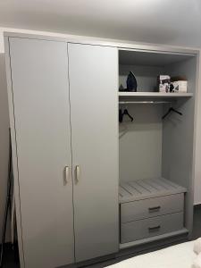 a white closet with white doors and a shelf at Charming Lower-Level Apartment in Il- Gżira +4 photos