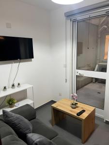 a living room with a couch and a coffee table at Charming Lower-Level Apartment in Il- Gżira