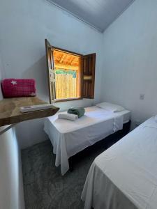 una habitación con dos camas y una ventana en Vila Kairós, en Caraíva