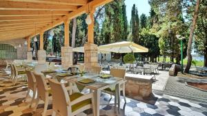 a patio with tables and chairs and an umbrella at Mobile Home Kamp Pineta - IB Studio in Fažana