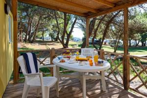 a white table and chairs on a wooden deck at Mobile Home Kamp Pineta - IB Studio in Fažana