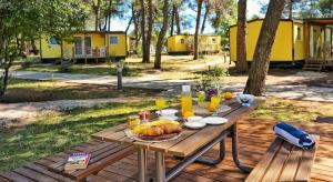 a picnic table with food and drinks on it at Mobile Home Kamp Pineta - IB Studio in Fažana