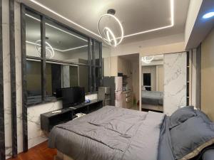 a bedroom with a bed and a television in it at Pakuwon Orchard Tanglin Surabaya in Surabaya +7 photos