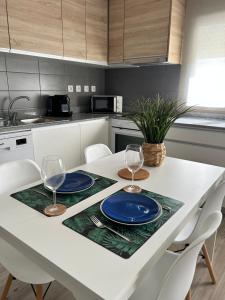 ナザレにあるMy beach's Apartments Nascenteのキッチン(白いテーブル、ワイングラス2杯付)