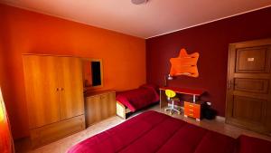 a bedroom with two beds and an orange wall at Dimora Ippocastano in Colli al Volturno