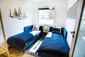 a room with two blue beds and a window at Apartament Bliżej Morza in Władysławowo