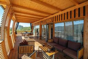 a screened in porch with a couch on a deck at Camp Ante-Gojko in Grebaštica