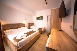 a hotel room with two beds and a flat screen tv at Hotel Perla Ksamil in Ksamil