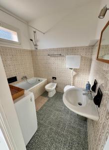 a bathroom with a sink and a tub and a toilet at Casa Ermy in Vercana +23 photos