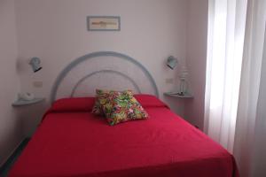 a red bed with a red blanket and a red pillow at Le Case dei pescatori - Sirena in Arcipelago Ponziano