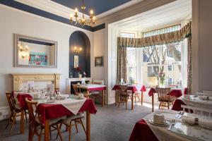 a restaurant with tables and chairs and a fireplace at Dunedin Guest House in Penzance
