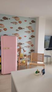 a pink refrigerator in a kitchen with a wallpaper at Newly renovated apartment in La Manga del Mar Menor