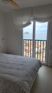 a bedroom with a bed and a large window at Newly renovated apartment in La Manga del Mar Menor