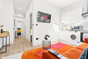 a living room with a couch and a tv on the wall at Stunning 4 Bed, Sleeps 10, Parking in London