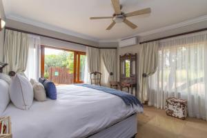 a bedroom with a large bed with a ceiling fan at Beautiful 4-bedroom, 33 Zebula in Warmbaths +29 photos