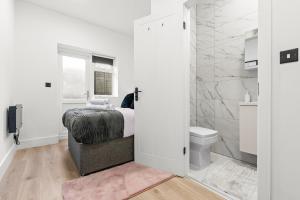 a white bedroom with a bed and a toilet at Stunning 4 Bed, Sleeps 10, Parking in London